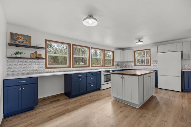 12411 E Gibbs Rd, Mica, WA 99023 - kitchen featuring freestanding refrigerator, stainless steel electric range oven, blue cabinetry, and backsplash