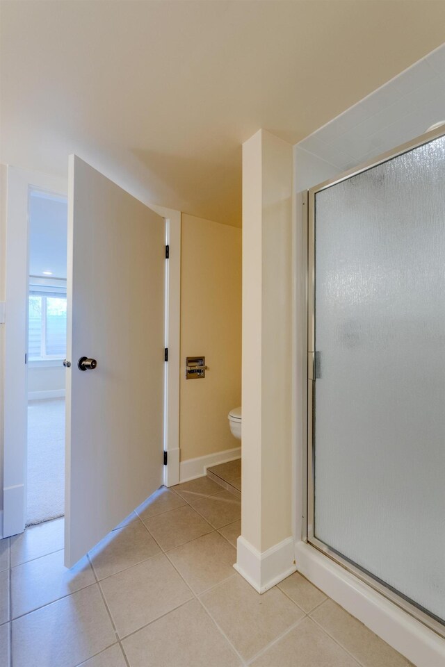 523 S Hatch St, Spokane, WA 99202 - bathroom featuring toilet, tile patterned flooring, a stall shower, and baseboards