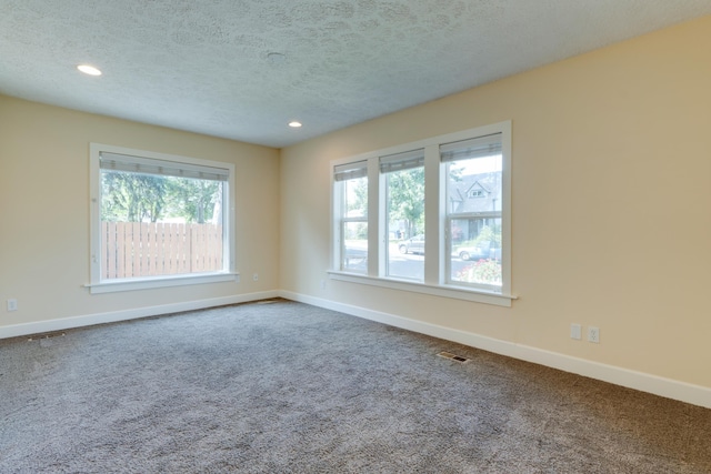 523 S Hatch St, Spokane, WA 99202 - spare room featuring dark colored carpet, plenty of natural light, a textured ceiling, baseboards, and recessed lighting