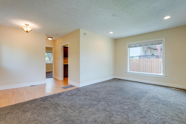 523 S Hatch St, Spokane, WA 99202 - unfurnished room featuring carpet floors, a textured ceiling, baseboards, recessed lighting, and wood finished floors