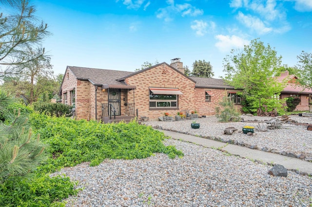 3342 W Riverview Dr, Spokane, WA 99205 - view of front of home with a chimney, brick siding, and a shingled roof