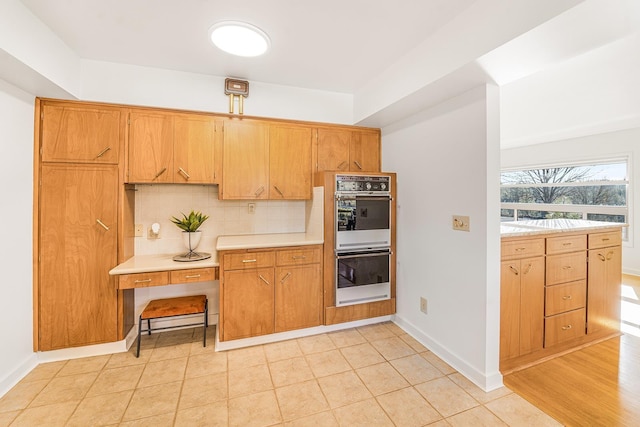 3342 W Riverview Dr, Spokane, WA 99205 - kitchen with double oven, light countertops, backsplash, baseboards, and light tile patterned floors