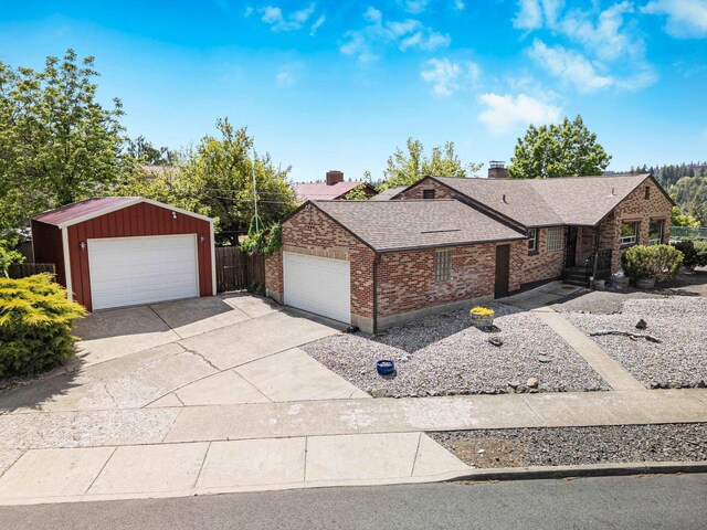 3342 W Riverview Dr, Spokane, WA 99205 - ranch-style house featuring brick siding, roof with shingles, a chimney, and a detached garage