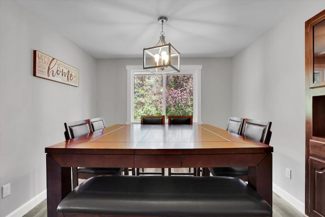 8428 N Susan Ct, Spokane, WA 99208 - dining space featuring a chandelier, wood finished floors, and baseboards
