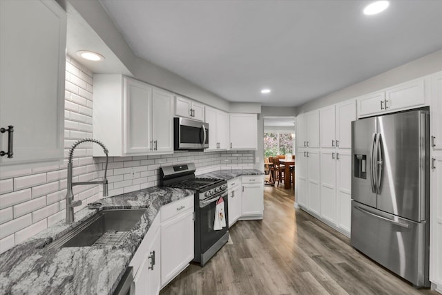 8428 N Susan Ct, Spokane, WA 99208 - kitchen with stainless steel appliances, a sink, stone counters, white cabinets, and recessed lighting