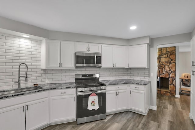 8428 N Susan Ct, Spokane, WA 99208 - kitchen featuring appliances with stainless steel finishes, a sink, dark stone counters, white cabinetry, and recessed lighting