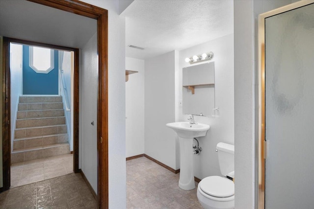 6106 W Kittitas Ct, Spokane, WA 99208 - full bath with toilet, a stall shower, a textured ceiling, and baseboards