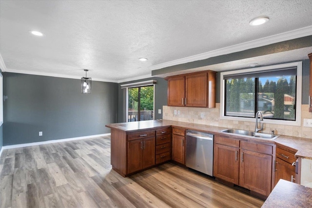 6106 W Kittitas Ct, Spokane, WA 99208 - kitchen featuring stainless steel dishwasher, a sink, a peninsula, tasteful backsplash, and ornamental molding