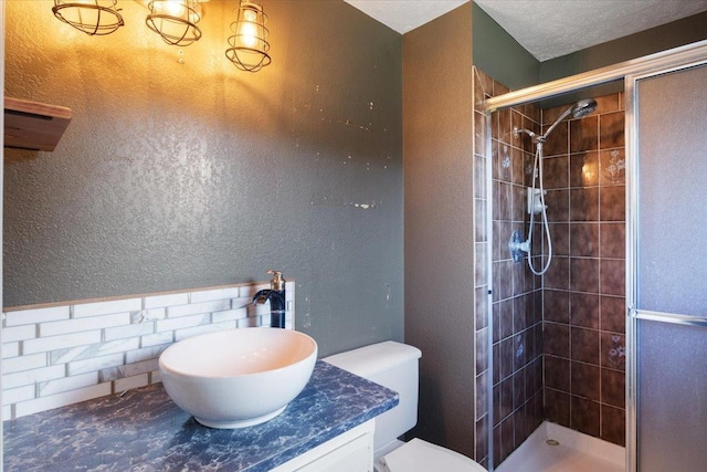 6106 W Kittitas Ct, Spokane, WA 99208 - full bathroom with a stall shower, toilet, vanity, and a textured wall
