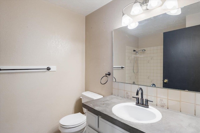 6106 W Kittitas Ct, Spokane, WA 99208 - full bathroom featuring toilet, backsplash, vanity, a shower, and a textured wall