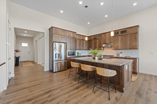 4756 W Lex Ave, Spokane, WA 99208 - kitchen with stainless steel appliances, under cabinet range hood, light wood-style floors, recessed lighting, and a breakfast bar area