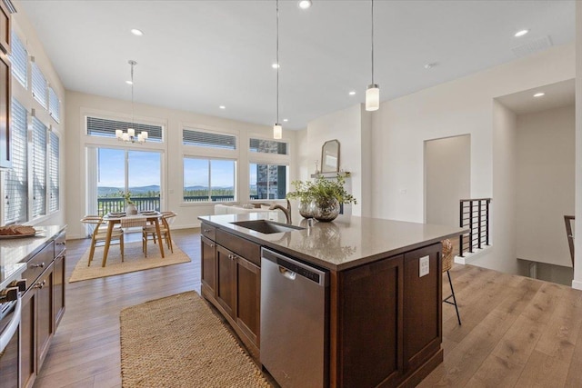 4756 W Lex Ave, Spokane, WA 99208 - kitchen with stainless steel dishwasher, a sink, light wood-style floors, an island with sink, and a chandelier