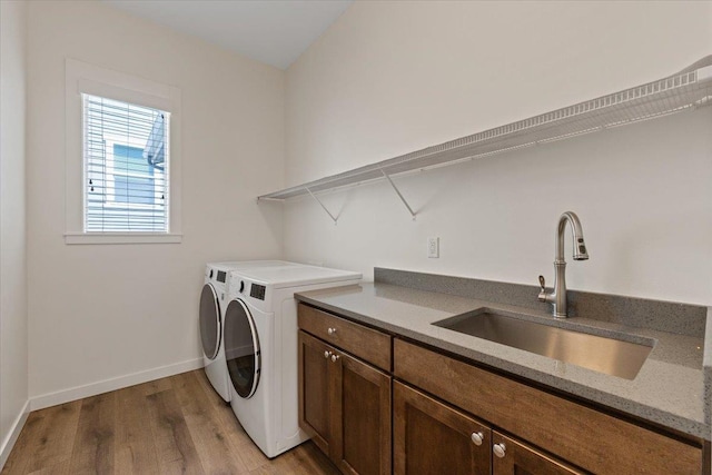 4756 W Lex Ave, Spokane, WA 99208 - washroom featuring washer and clothes dryer, light wood-style floors, baseboards, and cabinet space