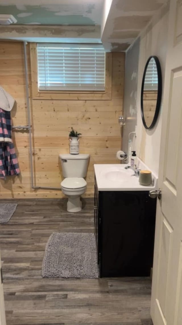 980 N Elm St, Colville, WA 99114 - bathroom with vanity, wood finished floors, toilet, and wood walls
