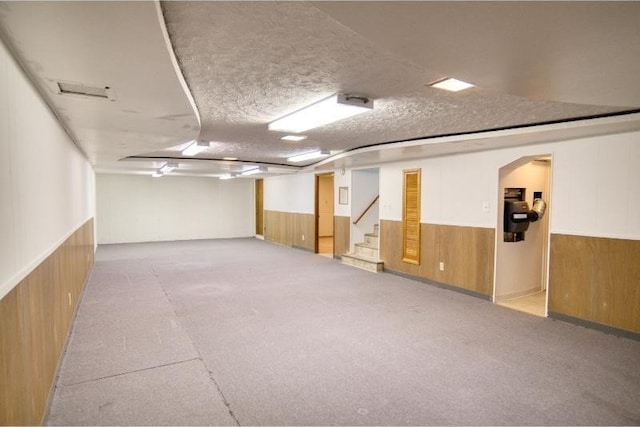 5516 N Fleming St, Spokane, WA 99205 - finished below grade area with wooden walls, wainscoting, stairway, a textured ceiling, and arched walkways