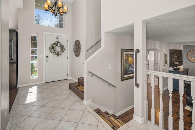 1216 W Candlewood Ct, Spokane, WA 99218 - entryway with a chandelier, plenty of natural light, light tile patterned flooring, baseboards, and a towering ceiling