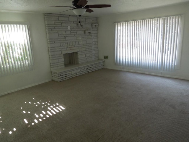 917 E Walton Ave, Spokane, WA 99207 - unfurnished living room featuring ceiling fan, healthy amount of natural light, a fireplace, and carpet flooring