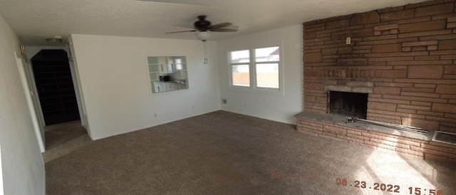 917 E Walton Ave, Spokane, WA 99207 - unfurnished living room with ceiling fan, carpet flooring, and a stone fireplace