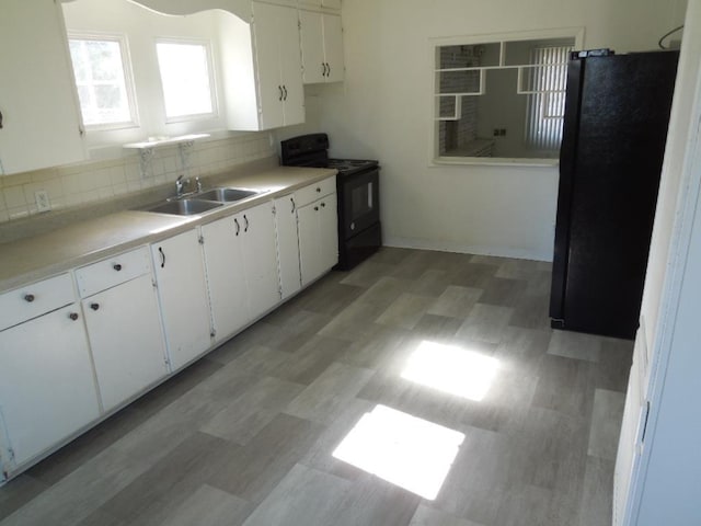 917 E Walton Ave, Spokane, WA 99207 - kitchen with black appliances, white cabinets, light countertops, tasteful backsplash, and light flooring