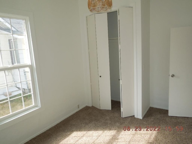 917 E Walton Ave, Spokane, WA 99207 - unfurnished bedroom with carpet flooring, multiple windows, and a closet