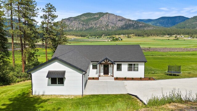 2419 C Indian Ridge Rd, Chewelah, WA 99109 - view of front of house with a trampoline, a mountain view, and a front yard