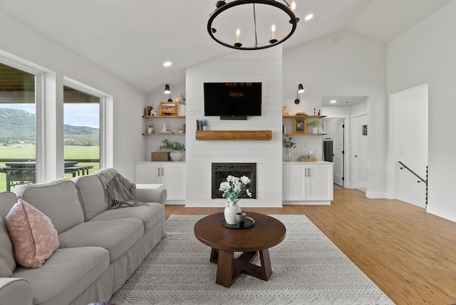 2419 C Indian Ridge Rd, Chewelah, WA 99109 - living area with lofted ceiling, a chandelier, light wood-style flooring, a large fireplace, and recessed lighting