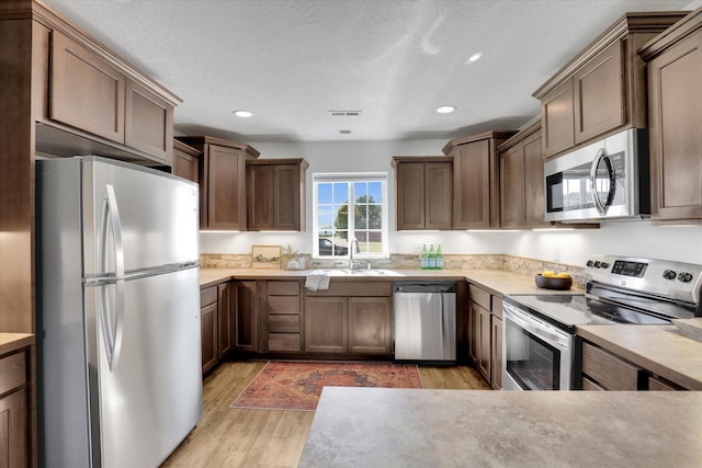 1002 N Oasis Ave, Deer Park, WA 99006 - kitchen featuring appliances with stainless steel finishes, a sink, light wood finished floors, light countertops, and recessed lighting
