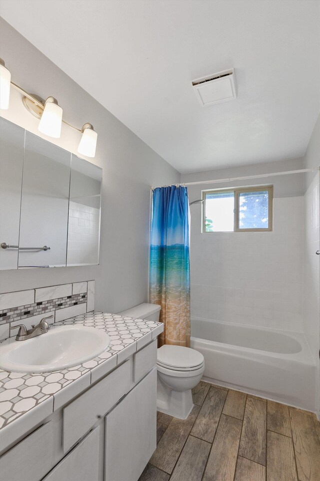 3424 E 32nd Ave, Spokane, WA 99223 - bathroom featuring wood finish floors, vanity, toilet, and shower / tub combo with curtain
