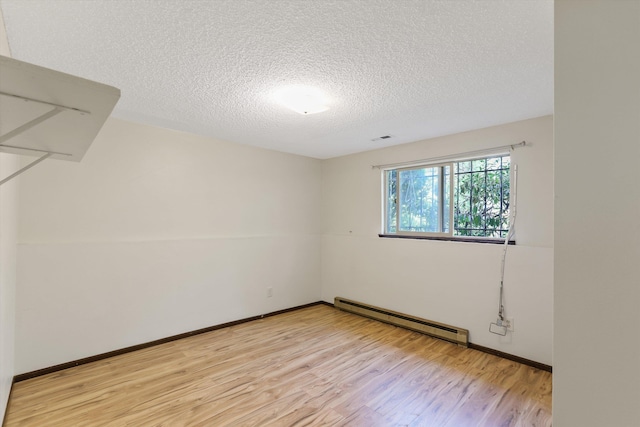 3424 E 32nd Ave, Spokane, WA 99223 - empty room with baseboard heating, light wood-style floors, a textured ceiling, and baseboards