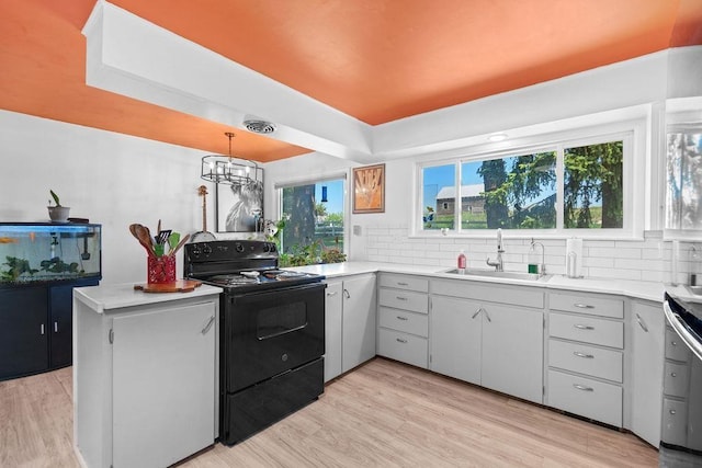 611 E Mill St, Latah, WA 99018 - kitchen with black / electric stove, a sink, light countertops, and decorative backsplash