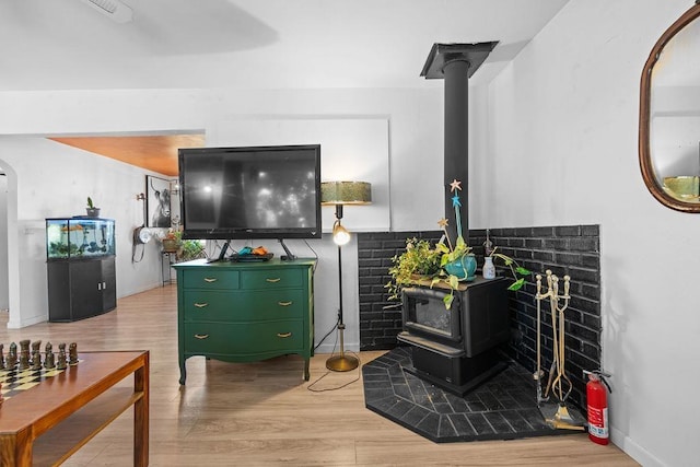 611 E Mill St, Latah, WA 99018 - living room with a wood stove, light wood-style floors, and baseboards