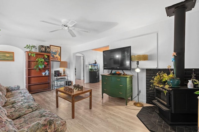 611 E Mill St, Latah, WA 99018 - living area with a wood stove, arched walkways, light wood-style floors, and a ceiling fan
