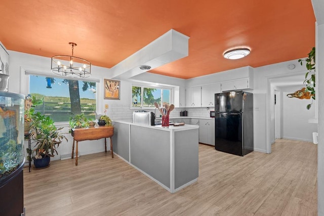 611 E Mill St, Latah, WA 99018 - kitchen featuring freestanding refrigerator, light countertops, a peninsula, and light wood-style floors