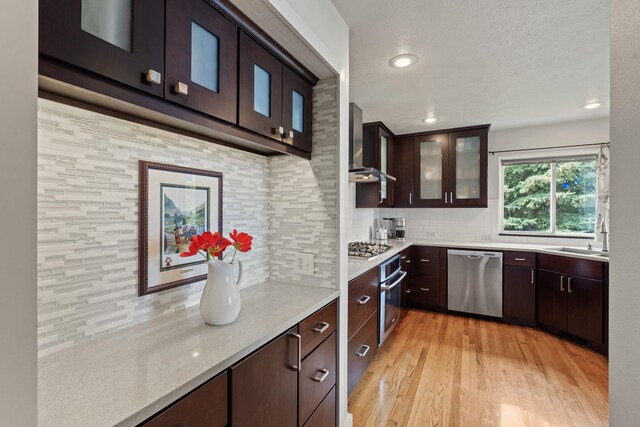526 W Willapa Ct, Spokane, WA 99224 - kitchen featuring stainless steel appliances, light countertops, backsplash, dark brown cabinetry, and light wood finished floors
