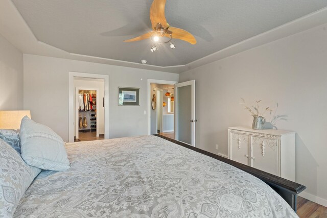 526 W Willapa Ct, Spokane, WA 99224 - bedroom with a walk in closet, wood finished floors, a ceiling fan, and baseboards