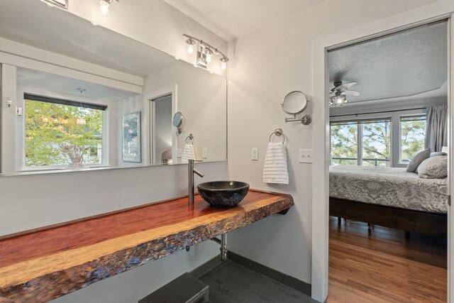 526 W Willapa Ct, Spokane, WA 99224 - bathroom with a sink, wood finished floors, ensuite bathroom, and baseboards