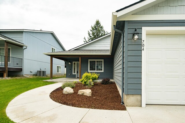 704 E Canterbury Ln, Colbert, WA 99005 - doorway to property with a garage, central air condition unit, a porch, and a yard