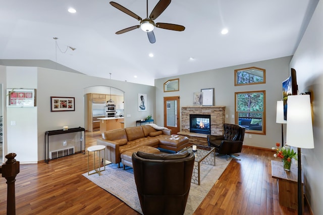 13906 E 39th Ln, Veradale, WA 99037 - living room featuring lofted ceiling, ceiling fan, a fireplace, light wood finished floors, and arched walkways
