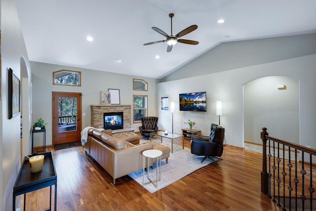 13906 E 39th Ln, Veradale, WA 99037 - living area featuring arched walkways, wood finished floors, a ceiling fan, lofted ceiling, and a stone fireplace