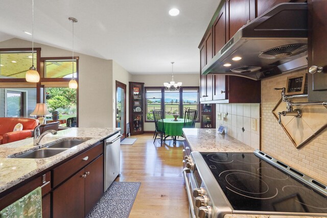 1002 N High Desert Dr, Deer Park, WA 99006 - kitchen featuring appliances with stainless steel finishes, a sink, wall chimney exhaust hood, light wood-style flooring, and decorative backsplash