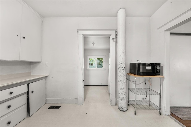 2304 E Dalke Ave, Spokane, WA 99207 - kitchen with black microwave, white cabinetry, and light countertops