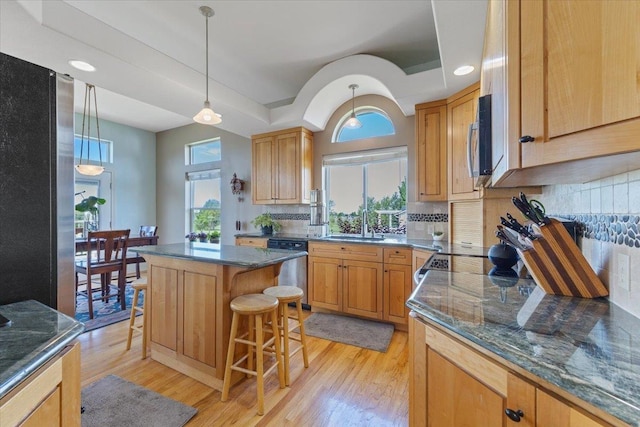 7920 S Parway Ln, Cheney, WA 99004 - kitchen featuring appliances with stainless steel finishes, a kitchen bar, light wood-style flooring, decorative backsplash, and recessed lighting