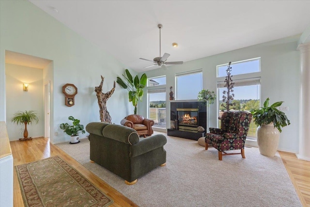 7920 S Parway Ln, Cheney, WA 99004 - living area featuring wood finished floors, ceiling fan, a fireplace, a towering ceiling, and baseboards