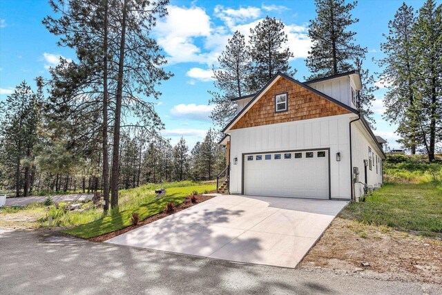 40083 Lake Terrace Ct, Loon Lake, WA 99148 - view of property exterior featuring a garage, concrete driveway, and a lawn