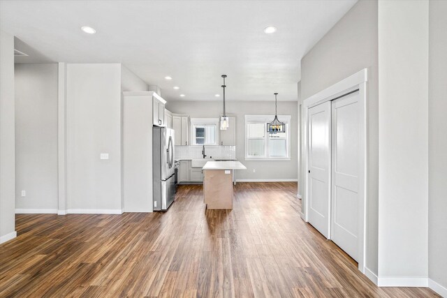 40083 Lake Terrace Ct, Loon Lake, WA 99148 - kitchen featuring stainless steel fridge with ice dispenser, a sink, light countertops, baseboards, and wood finished floors