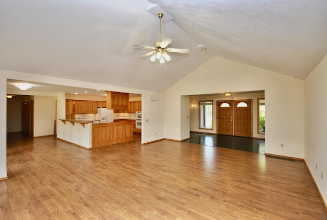 3704 E Pineland Rd, Colbert, WA 99005 - unfurnished living room with light wood finished floors, high vaulted ceiling, baseboards, and a ceiling fan