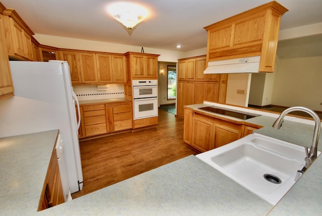 3704 E Pineland Rd, Colbert, WA 99005 - kitchen with a sink, white appliances, under cabinet range hood, wood finished floors, and light countertops