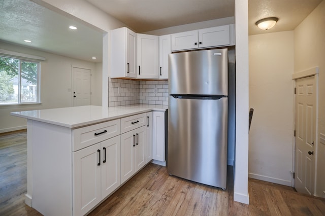 5320 N Ash St, Spokane, WA 99205 - kitchen with freestanding refrigerator, light wood-style floors, white cabinetry, tasteful backsplash, and recessed lighting