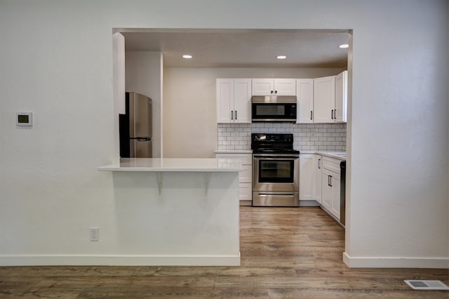 5320 N Ash St, Spokane, WA 99205 - kitchen featuring appliances with stainless steel finishes, backsplash, baseboards, light countertops, and white cabinetry