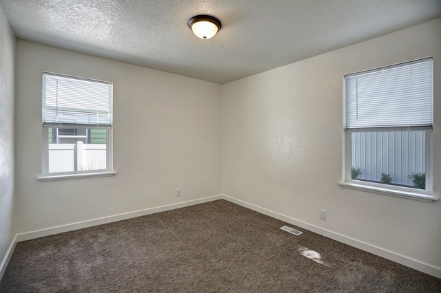 5320 N Ash St, Spokane, WA 99205 - empty room with dark carpet, baseboards, and a textured ceiling